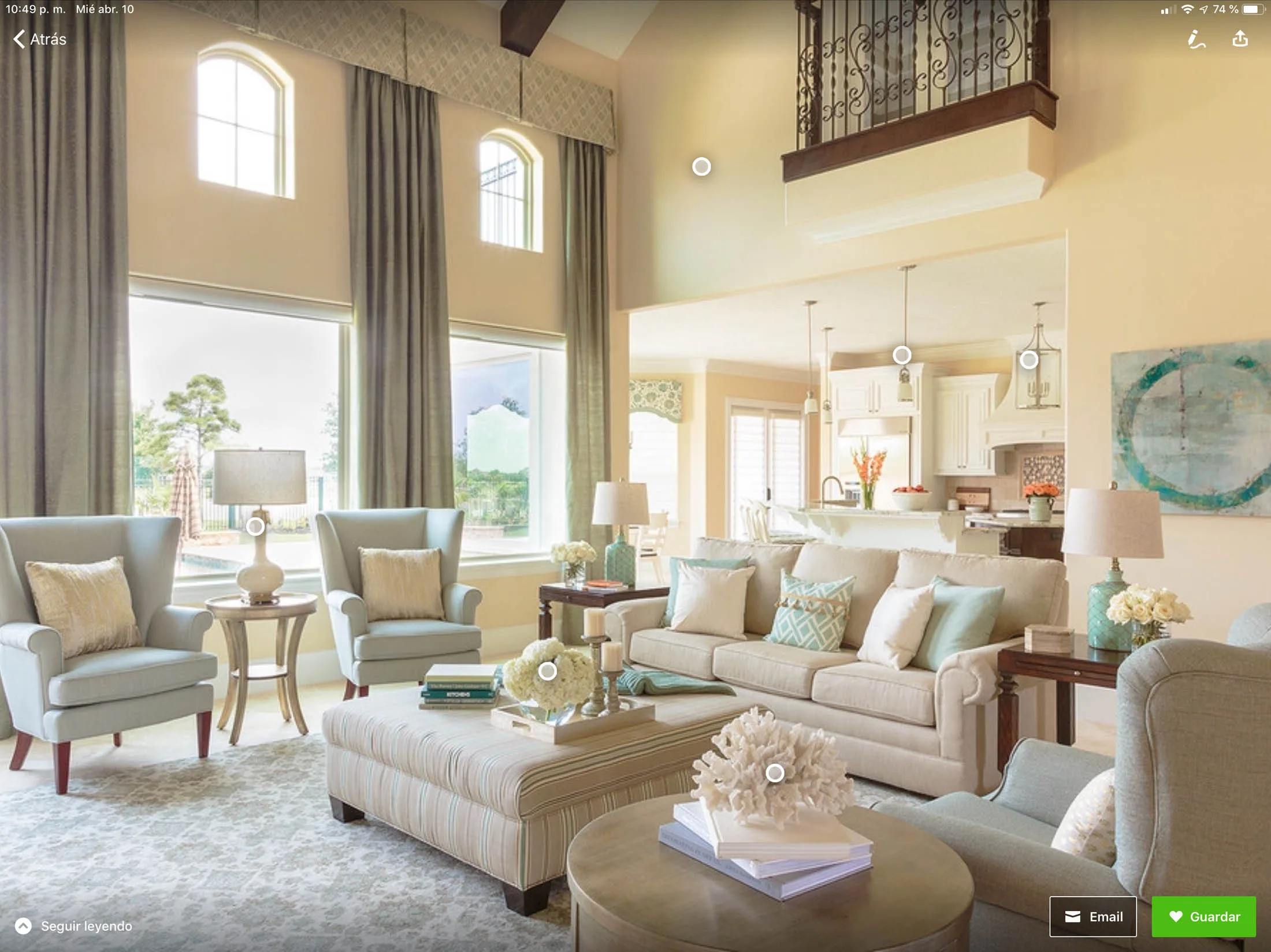 Bright and airy living room featuring elegant furnishings, light blue armchairs, a beige sofa with decorative pillows, and large windows allowing natural light, showcasing Arreguin's Painting's expertise in enhancing residential interiors.