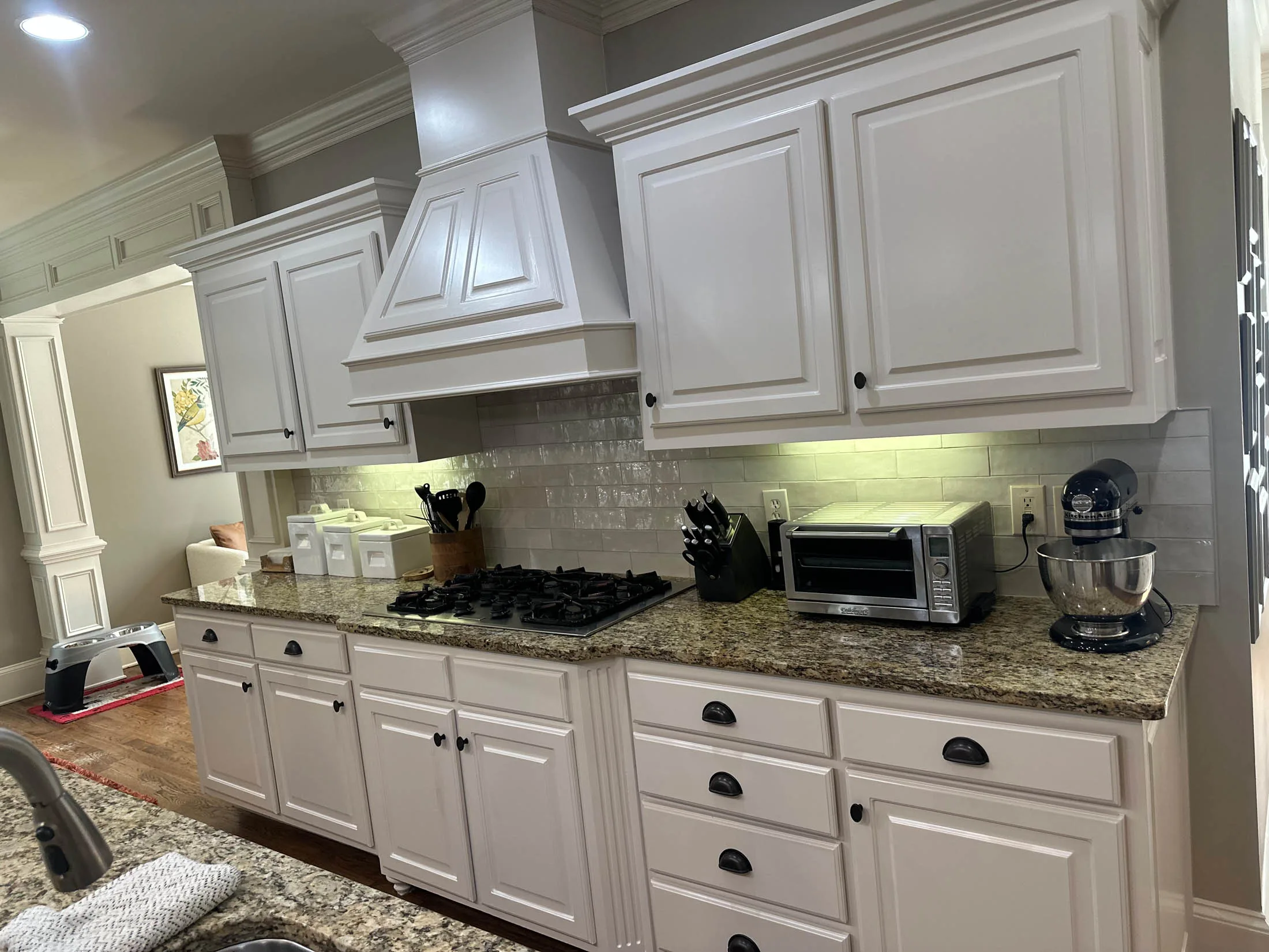 Modern kitchen with white cabinets, granite countertops, stainless steel appliances, and a gas stove, reflecting a fresh and updated residential space in Marietta, GA.
