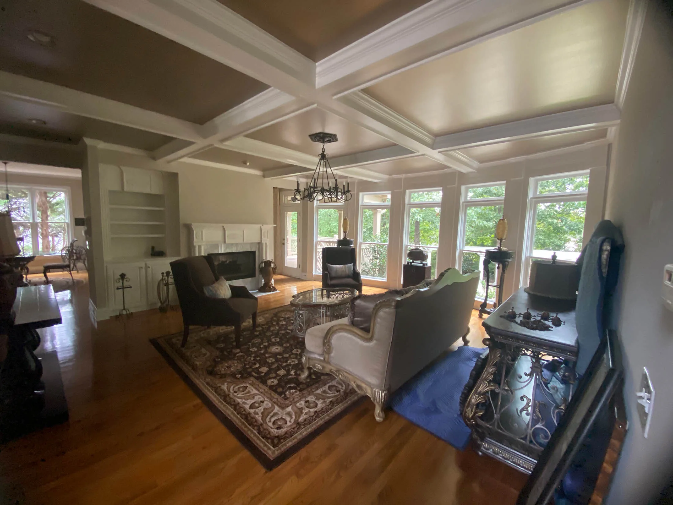 Elegant living room interior featuring a coffered ceiling, hardwood floors, and stylish furnishings, showcasing quality craftsmanship ideal for home improvement projects by Arreguin's Painting in Marietta, GA.