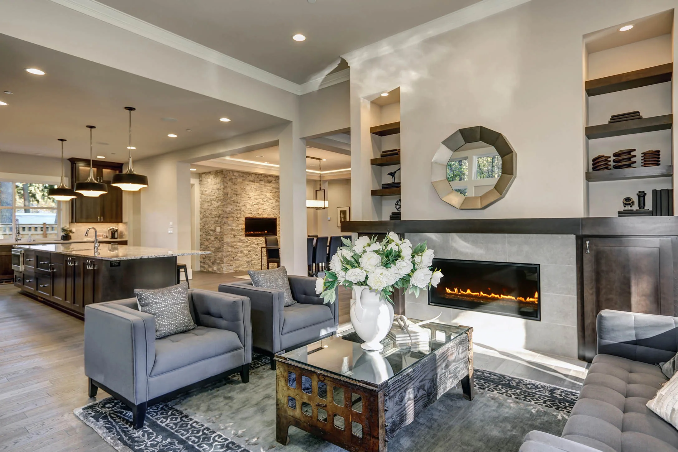Modern residential living room with stylish gray sofas, decorative coffee table, elegant floral arrangement, and contemporary fireplace, showcasing high-quality interior painting and design elements in Marietta, GA.